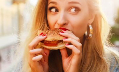 mulher comendo hambúrguer saudável fast food