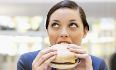 receitas de hamburguer mulher comendo fast food