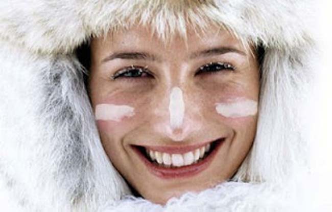 cuidados com a pele no inverno mulher com roupa de frio e protetor no rosto